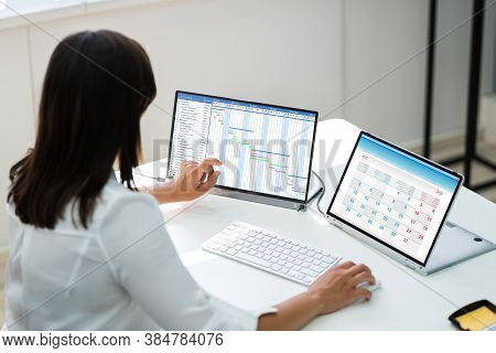 Employee Working On Calendar Schedule And Staff Time Sheet