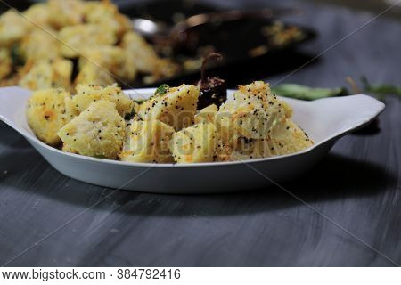 Idli Fry Made From Fermented Rice And Urad Daal Cakes Called Idis On A Dark Background.