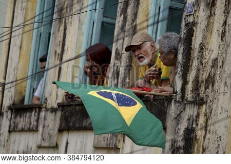 Salvador, Bahia / Brazil - July 2, 2015: Person Holds Brazilian Flag In The Lapinha Neighborhood Of 