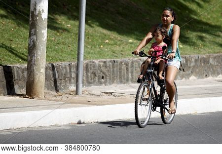Salvador, Bahia / Brazil - February 21, 2016: Woman Is Seen Riding A Bicycle With A Child In The Dik