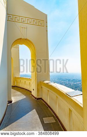 Empty Outside Corridor On Greek Design Building With Arch/ Arched Walls And City View In Background.