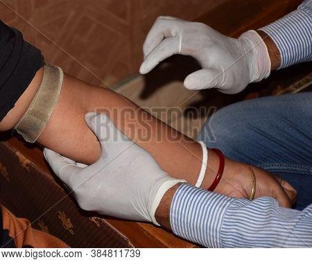 A Doctor Checking The Arm Ulnar Nerve Of A Patient Before Taking Out Blood From A Syringe For Medica