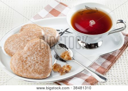 Cookies hjerte, brun farin, skeen, sort te, underkop på dug
