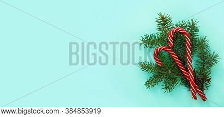 Spruce Branches And Red Candies On A Blue Background. Flat Lay, Top View, Copy Spacel. Christmas Con