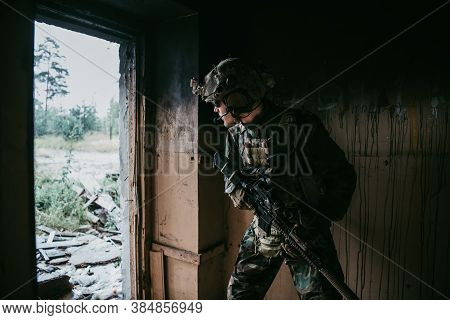 Soldier In Full Us Marsoc Armed With Assault Rifle Run Through The Abandoned Building. Military Clas