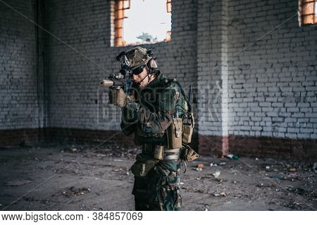 Military Soldier In The Form Holds In The Hands An Assault Rifle, Check Possible Enemies Around The 
