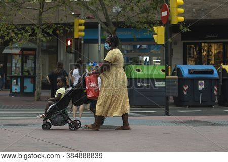 Zaragoza, Spain - August 18, 2020: A Black Inmigrant Woman, With Face Masks, Due To The Coronavirus 