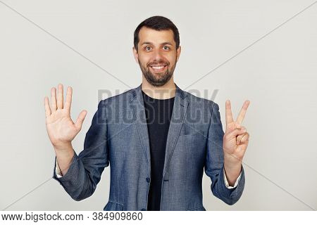 Young Businessman Man With Beard Smiling, Showing Number Seven With Fingers On Hand, Smiling Confide