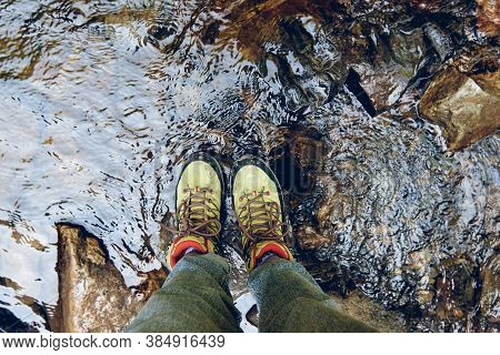 Hiking Boots In Outdoor Action. Top View Of Boot On The Trail. Close-up Legs In Jeans And Sport Trek