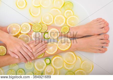 Faceless Beautiful Young Woman Takes A Bath With Milk Lemons And Lime. Cropped Photo. Close-up Of Fe