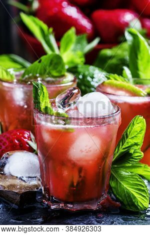 Alcoholic Cocktail Strawberry Mojito With White Rum, Syrup, Soda, Lime, Mint And Ice, Black Backgrou
