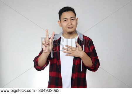 Portrait Of Happy Asian Man Making Pledge Gesture, Hand On Chest Holding Heart, Making Promise