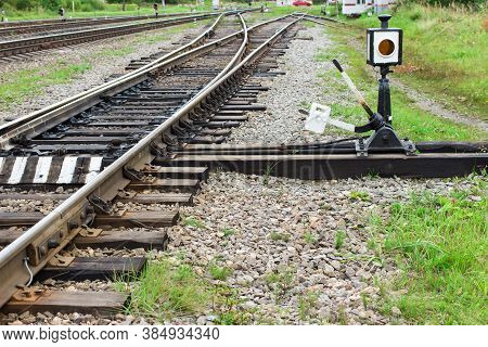 Arrow For Switching The Railway With Rail Track Elements. Old Railway Tracks With Wooden Sleepers.