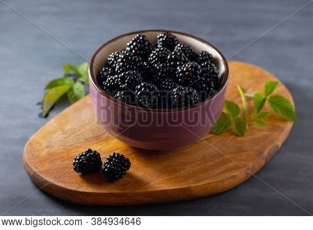 Fresh Blackberries In A Bowl On A Rustic Board On The Table. Close-up.