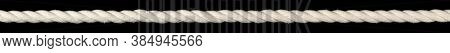 Long white cotton rope cord stretched straight and taut. Isolated on black.