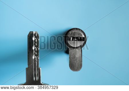 A Door Lock Cylinder Core With Key On The Blue Background. The Cylinder Of The Lock With Key. Instal