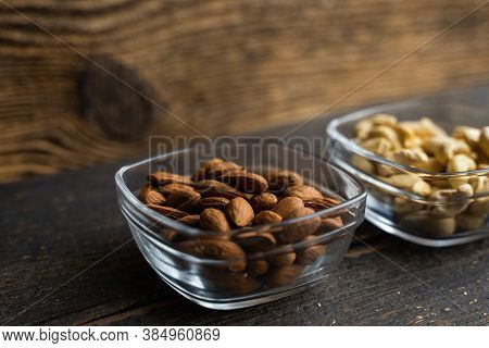 Almond, Cachew And Walnut In A Small Plates Which Standing On A Black Table. Nuts Is A Healthy Veget