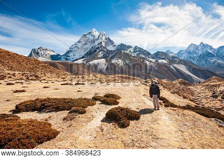 Young Woman Trekking In Valley Leading To The Everest Base Camp With Ama Dablam Peak. Trekking In Ne
