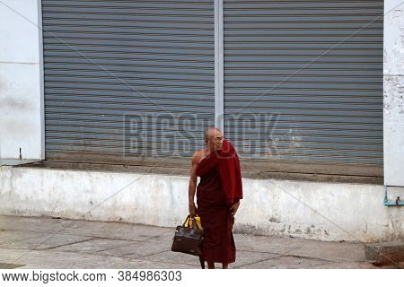 Yangon, Myanmar Feb 24, 2019: Myanmarese Buddhist Monk Standing Beside The Road In Yangon.