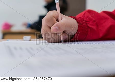 Hand Student Use Pencil Writing On Paper Optical Form Of Standardized Test Examination, Answer Sheet