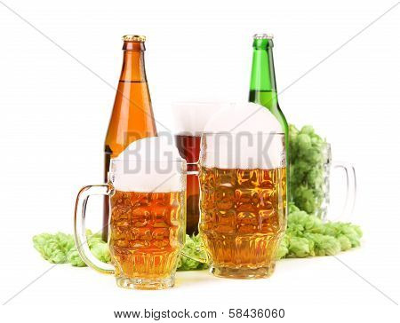 Two mugs of beer with foam and bottels