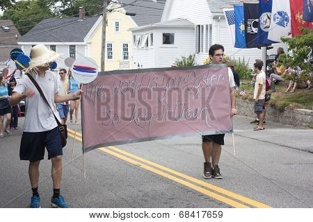 Men carry sign in the Wellfleet 4th of July Parade in Wellfleet, Massachusetts.