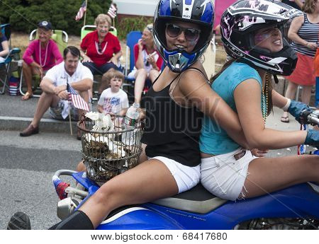 Wellfleet, Massachusetts, USA-July 4, 2014: Two young women riding on a motorcycle in the Wellfleet