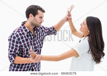 Fearful brunette being overpowered by boyfriend on white background