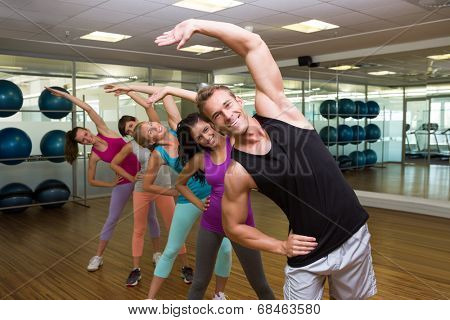 Fitness class led by handsome instructor at the gym