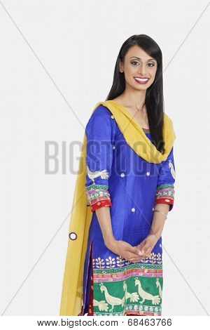 Portrait of beautiful Indian female traditional wear standing against gray background