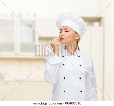 cooking, gesture and food concept - smiling female chef showing delicious gesture