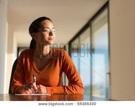 beautiful young woman relax and work on laptop computer while listening music on heaphones and read book at home