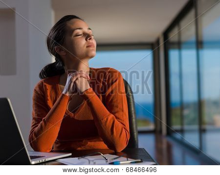 beautiful young woman relax and work on laptop computer while listening music on heaphones and read book at home