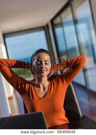 beautiful young woman relax and work on laptop computer while listening music on heaphones and read book at home