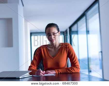 beautiful young woman relax and work on laptop computer while listening music on heaphones and read book at home