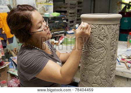 Woman cuts traditional tattoo motives decoration at kaolin, Kuching, Malaysia.