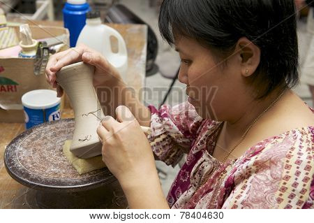 Woman cuts traditional tattoo motives decoration at kaolin, Kuching, Malaysia.