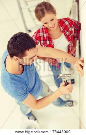repair, building and home concept - smiling couple renovating new home