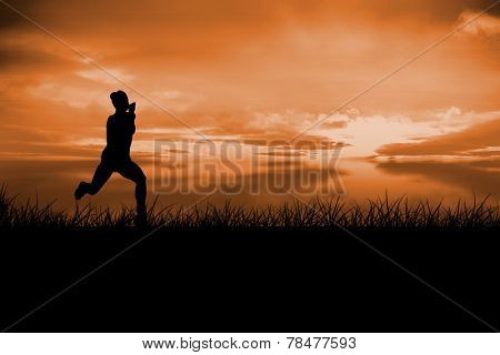 Fit brunette running and jumping against a couldy day