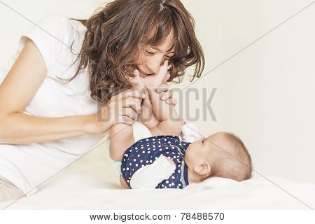 Young And Happy Mother Having Good Time Together With Her Baby Infant