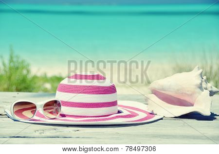 Sun glasses and hat against tropical beach of Great Exuma island, Bahamas