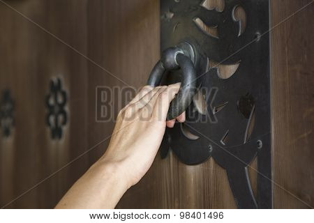 woman hand holding an old door knocker