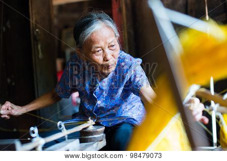Old woman are weaving silk