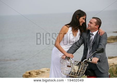 Recém casados - sorrindo a noiva e o noivo com idade da motocicleta