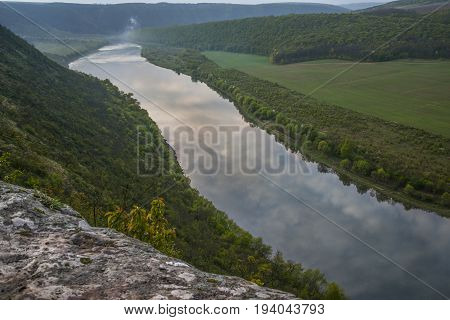 Dnestr (Dniester) river top view. Sky and clouds reflect in water.