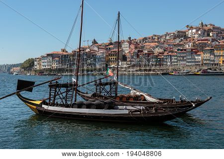 Traditional Rabelo Boat on the Bank of the River Douro and Colorful Facades of Typical Houses- Porto Portugal