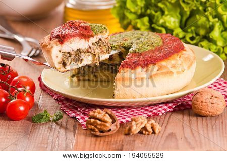 Calzone with walnuts and endive on green dish.