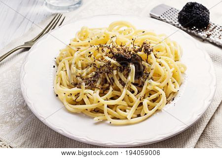 Strangozzi italian wheat pasta with truffle on a light background.