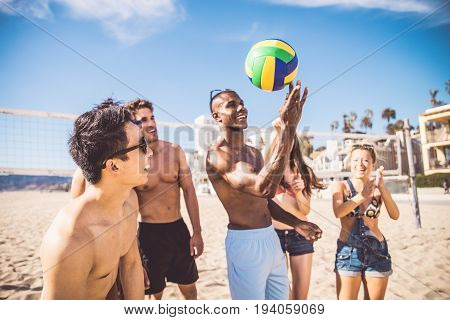 Group of friends playing beach volley - Multi-ethic group of people having fun on the beach