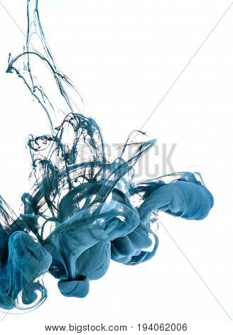 Ink swirl in a water on white background. The paint in the water. Soft dissemination a droplets of colored ink in water close-up. Explosion of color splashes acrylic ink.